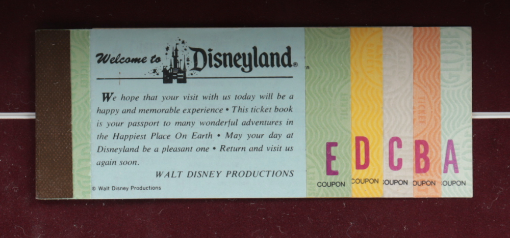 Thomas Kinkade 50th Anniversary "Disneyland" 20.5x22.5 Custom Framed Canvas on Wood Display with Vintage Ticket Booklet at PristineAuction.com Thomas Kinkade 50th Anniversary "Disneyland" 20.5x22.5 Custom Framed Canvas on Wood Display with Vintage Ticket Booklet at PristineAuction.com