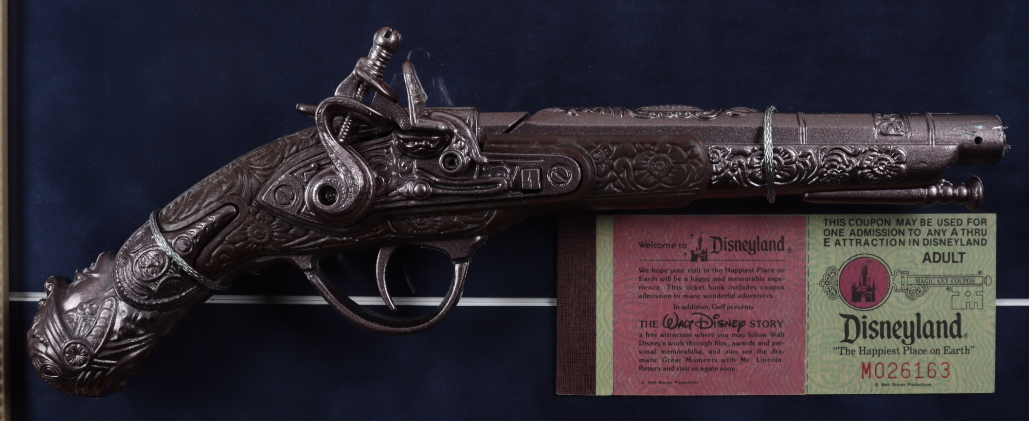 "Pirates of the Caribbean" 15x26 Custom Framed Display with Disneyland Ticket Book & Pirates Pistol at PristineAuction.com "Pirates of the Caribbean" 15x26 Custom Framed Display with Disneyland Ticket Book & Pirates Pistol at PristineAuction.com