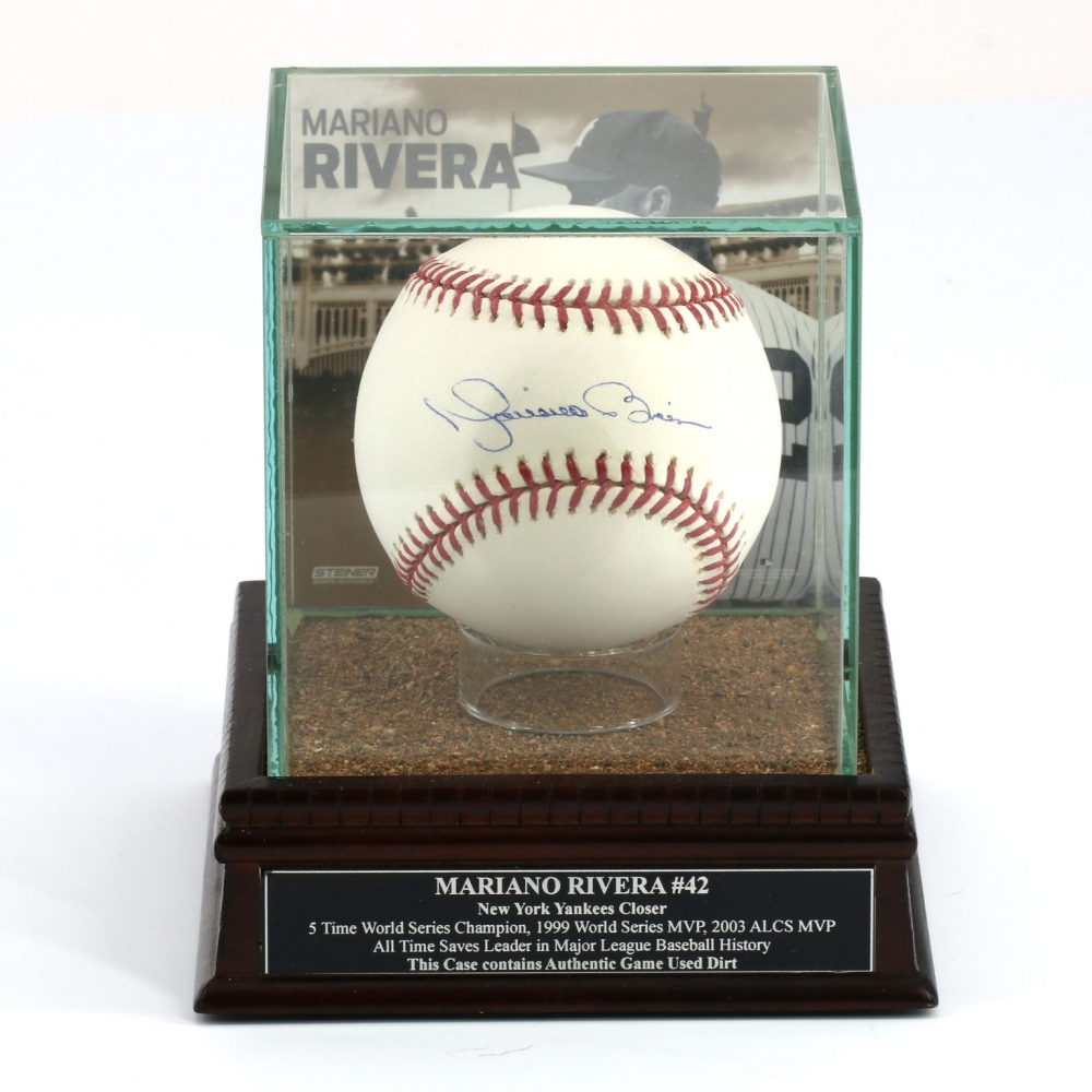 A Mariano Rivera signed baseball encased in a display with game-used dirt, showcasing the iconic sweet-spot signature.