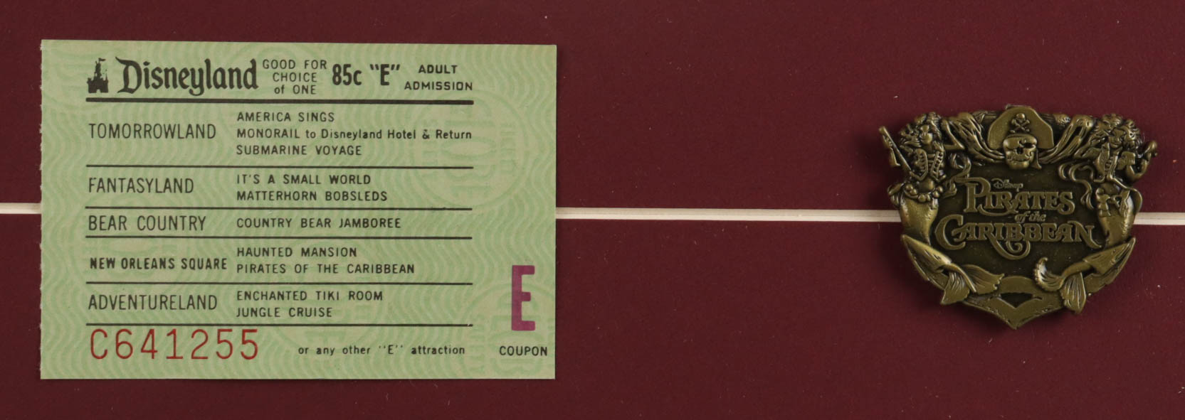 Disneyland "Pirates of the Caribbean" Custom Framed Poster Print Display with Vintage Disneyland 'E' Ticket & Brass Official Ride Emblem at PristineAuction.com Disneyland "Pirates of the Caribbean" Custom Framed Poster Print Display with Vintage Disneyland 'E' Ticket & Brass Official Ride Emblem at PristineAuction.com