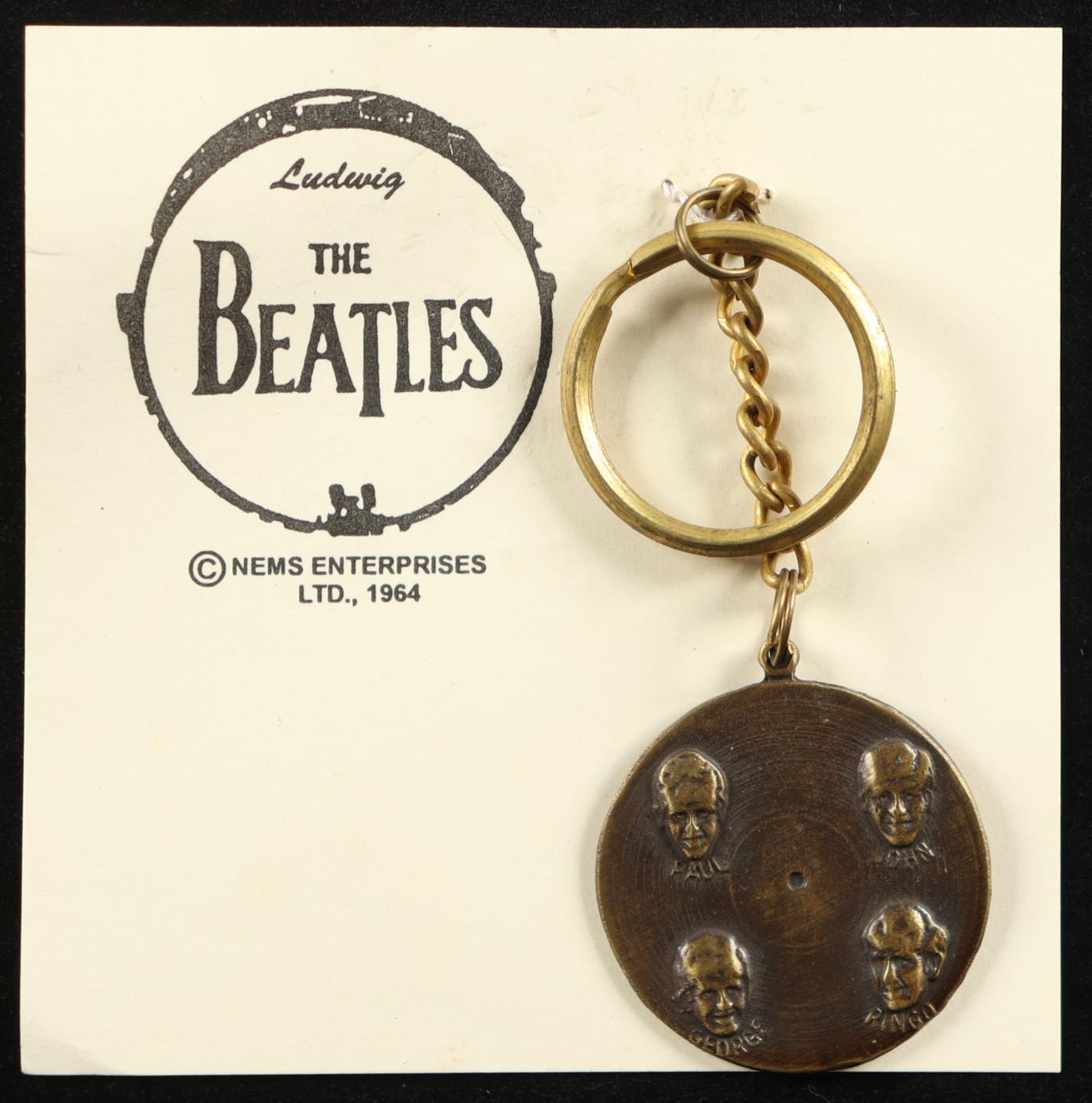 1964 The Beatles Vintage Brass Nems Keychain with Original Packaging at PristineAuction.com 1964 The Beatles Vintage Brass Nems Keychain with Original Packaging at PristineAuction.com
