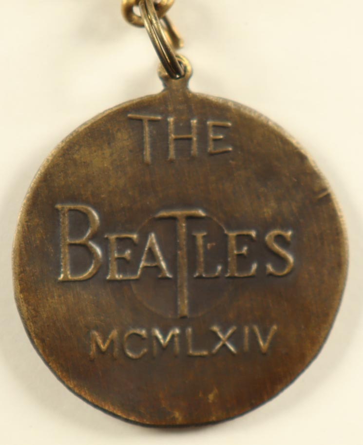 1964 The Beatles Vintage Brass Nems Keychain with Original Packaging at PristineAuction.com 1964 The Beatles Vintage Brass Nems Keychain with Original Packaging at PristineAuction.com