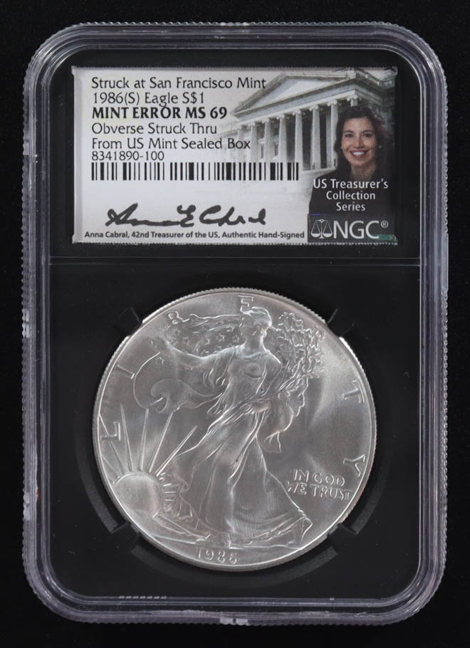 Mint Error 1986-(S) American Silver Eagle $1 Coin Struck at San Francisco Obverse Struck Thru Black Core Holder - Anna Escobedo Cabral Signed Label (NGC MS69) at PristineAuction.com Mint Error 1986-(S) American Silver Eagle $1 Coin Struck at San Francisco Obverse Struck Thru Black Core Holder - Anna Escobedo Cabral Signed Label (NGC MS69) at PristineAuction.com