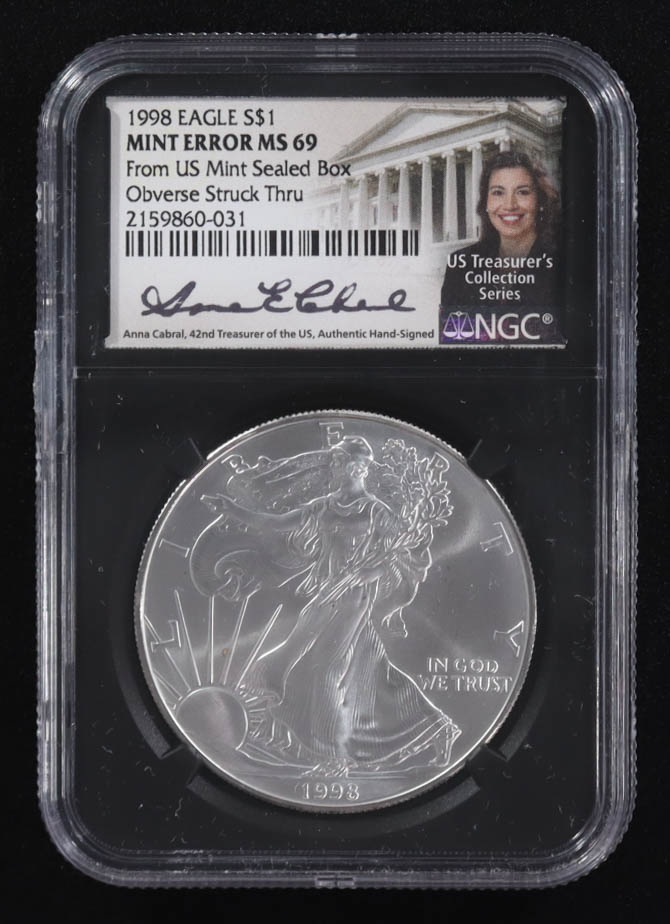 Mint Error 1998 American Silver Eagle $1 Coin Obverse Struck Thru Black Core Holder - Anna Escobedo Cabral Signed Label (NGC MS69) at PristineAuction.com Mint Error 1998 American Silver Eagle $1 Coin Obverse Struck Thru Black Core Holder - Anna Escobedo Cabral Signed Label (NGC MS69) at PristineAuction.com